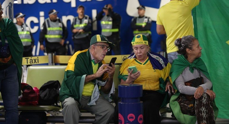 Apoiadores aguardam a chegada do ex-presidente Jair Bolsonaro no Aeroporto de Brasília