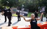 Nesta outra foto, a mesma manifestante segura dois cartazes com as seguintes mensagens: 'Deixe o acerto de contas começar' e 'Não deixe o Trump te enganar'