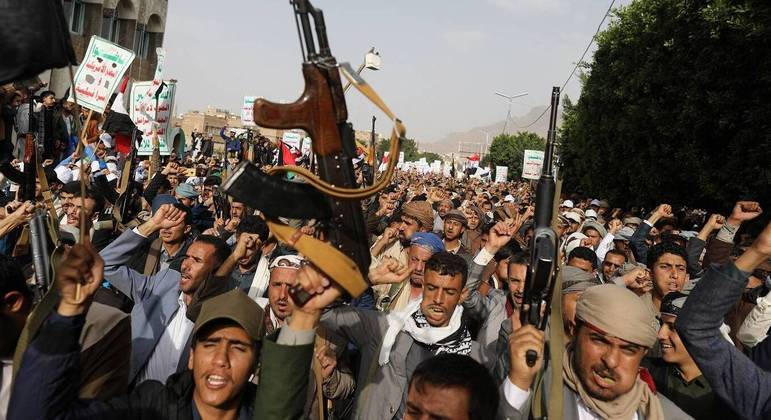 Apoiadores dos houthis exibem armas em manifestação em Sanaã, capital do Iêmen