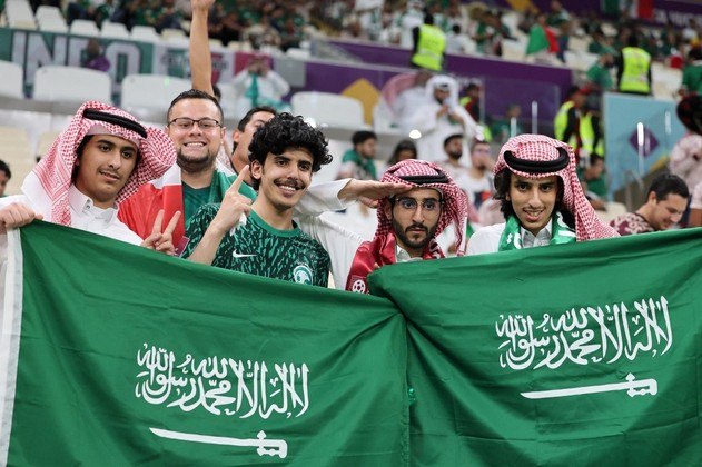 Apoiadores da Arábia Saudita erguem a bandeira do paísNão saia daí! Brasileiro 'bate recorde' e é a pessoa que mais assistiu a jogos da Copa do Mundo em estádios