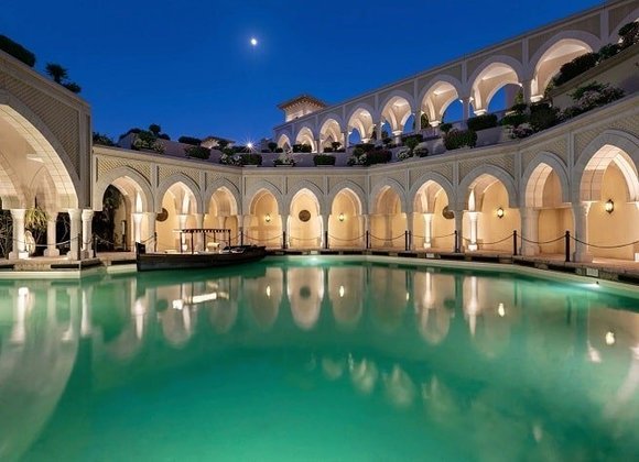 Área externa mostrando a arquitetura de um palácio árabe, com direito a piscina