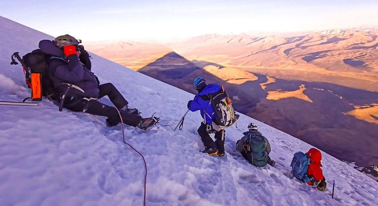 Aretha guia um grupo de pessoas na montanha Vulcão Sajama, na Cordilheira dos Andes