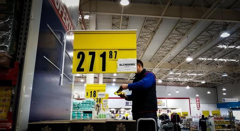 Homem remarca preços em supermercado na Argentina