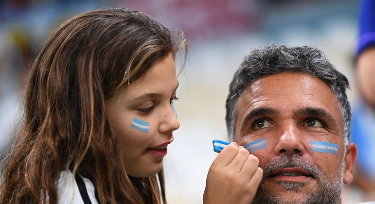 Filha pinta rosto do pai para acompanhar a seleção da Argentina contra a Croácia