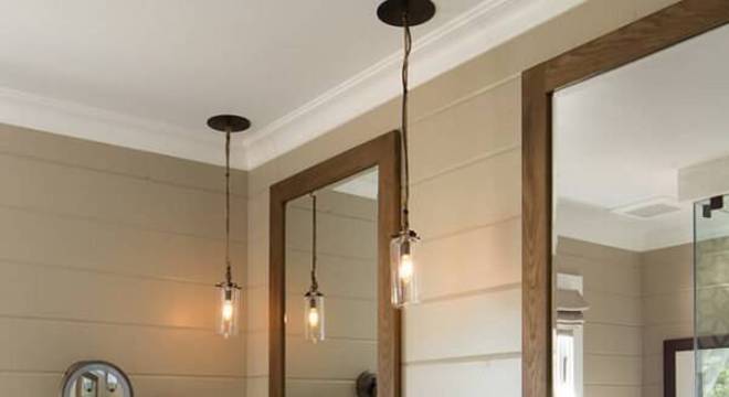 Armário de banheiro de madeira escura destaca a bancada com granito branco