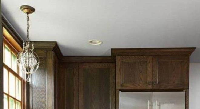 Armário de cozinha de madeira com tonalidade escura traz sofisticação ao ambiente