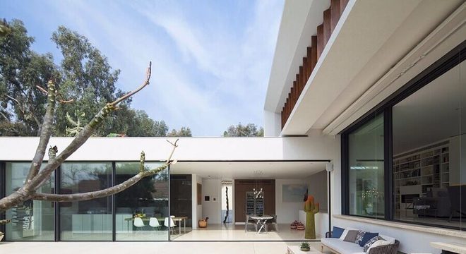 arquitetura moderna para casa em l com piscina e paredes de vidro 