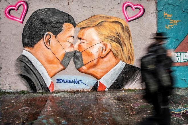 Em Berlim, Alemanha, uma crítica aos líderes mundiais brigões: Donald Trump e Xi Jinping aparecem se beijando usando máscaras