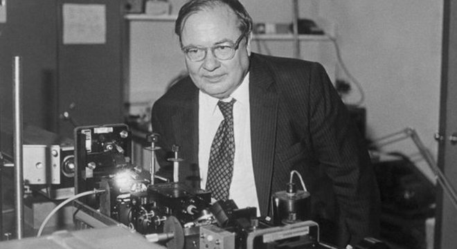 Arthur Schawlow posando com laser em um laboratório em Stanford, Estados Unidos 