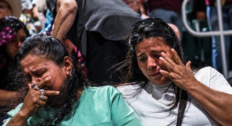 Pessoas choram enquanto acompanham as homenagens às vítimas do tiroteio em Uvalde