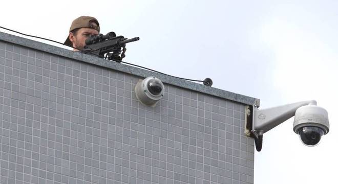 Atirador acompanha movimentação em frente ao prédio da PF, em Curitiba