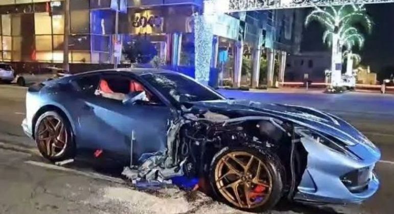 Carro na cor azul e com rodas douradas ficou destruído com a batida