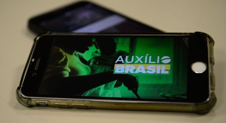 Celular com o logo do Auxílio Brasil aberto
