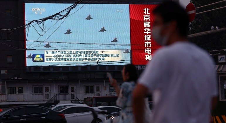 Telão exibe imagens de aviões do Exército chinês, em Pequim 