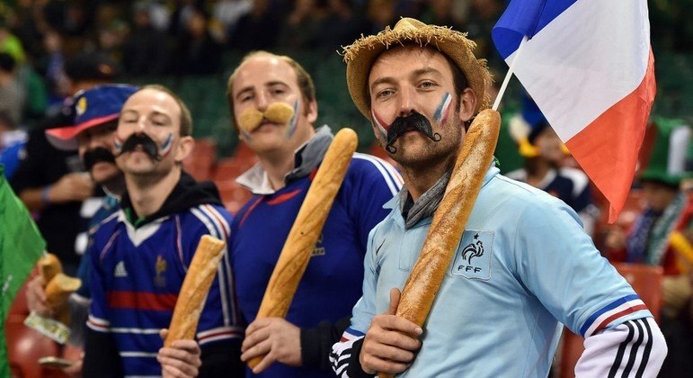 Torcedores franceses seguram baguetes antes de uma partida de Rugby, no País de Gales