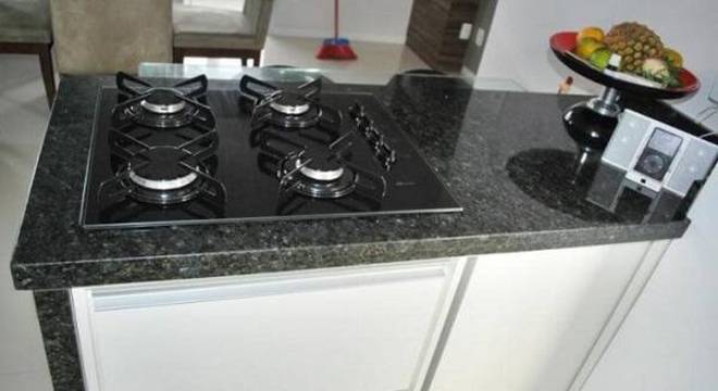 Bancada de granito verde ubatuba com fogão cooktop e fruteira