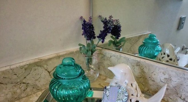 Bandeja decorada com porcelanas utilizada como enfeites para pia de banheiro