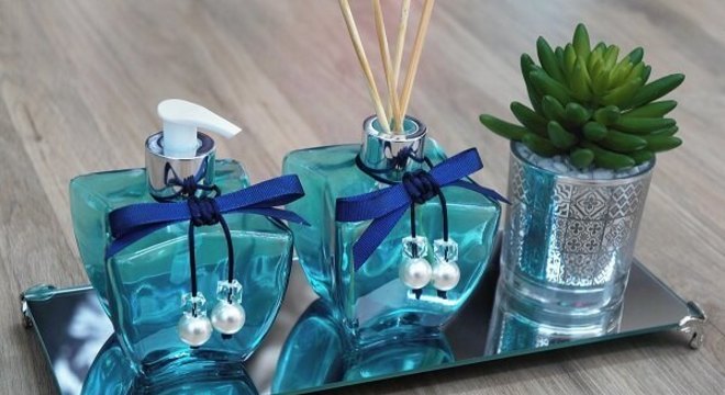 Bandeja espelhada com saboneteira utilizada como enfeites para pia de banheiro