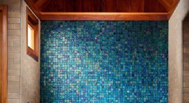 banheiro com pastilha de vidro azul e banheira de inox