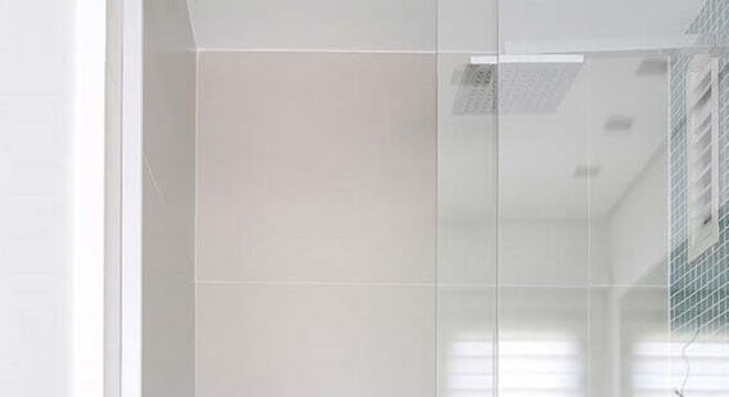 banheiro com pastilha de vidro azul no nicho e parede de box