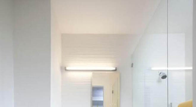 banheiro todo branco decorado com gabinete de madeira 