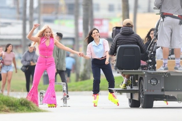 Margot andou de patins usando uma roupa totalmente rosa, ao lado da atriz America Ferrera
