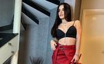 Um dos looks escolhidos por Bia para curtir o último fim de semana era composto de saia combinando com a bolsa vermelha e top fazendo bonito com as botas pretas de salto plataforma