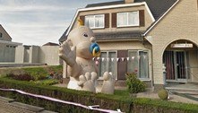 Tem um bebê inflável gigantesco em frente a uma casa na Bélgica