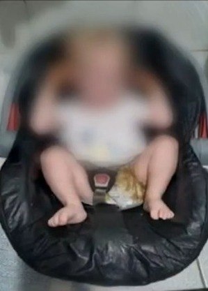 Bebê preso ao cinto de cadeirinha e sujo de fezes