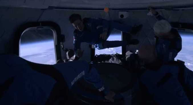 Tripulantes da New Shepard interagem durante experiência de viajar ao espaço