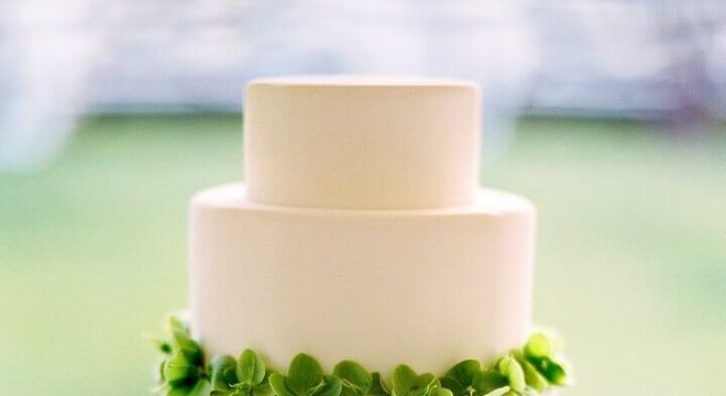 bolo de casamento branco decorado com folhas verdes