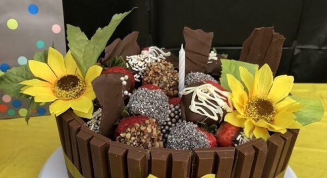 Bolo feito com Kit Kat e morangos para festa tema girassol