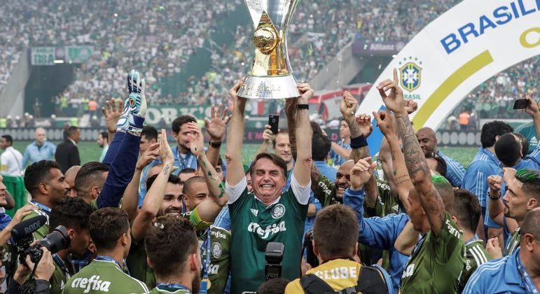 Bolsonaro ergue o troféu do Palmeiras campeão brasileiro de 2018. Um flerte verde