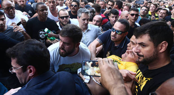 O candidato Jair Bolsonaro Ã© carregado durante evento em Juiz de Fora