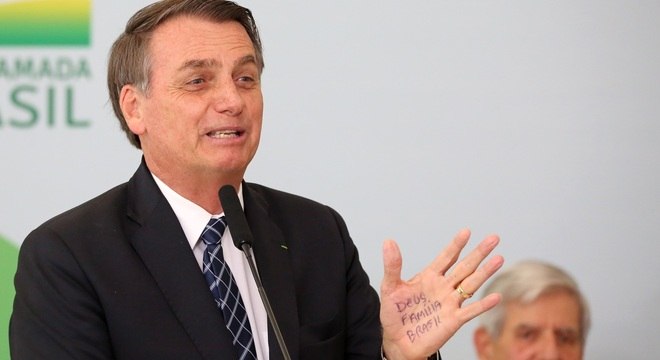 Bolsonaro com as palavras Deus, família e Brasil na mão no lançamento do Médicos pelo Brasil