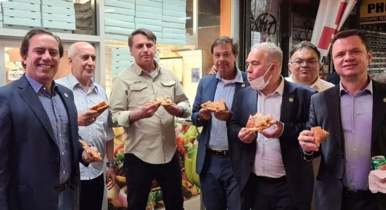 O presidente Jair Bolsonaro e sua comitiva em Nova York comendo pizza na rua