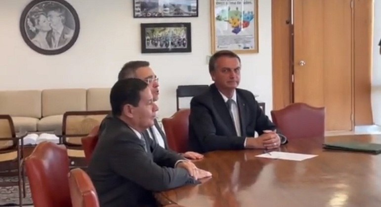 André Mendonça (ao centro) com o vice-presidente Mourão e o presidente Bolsonaro