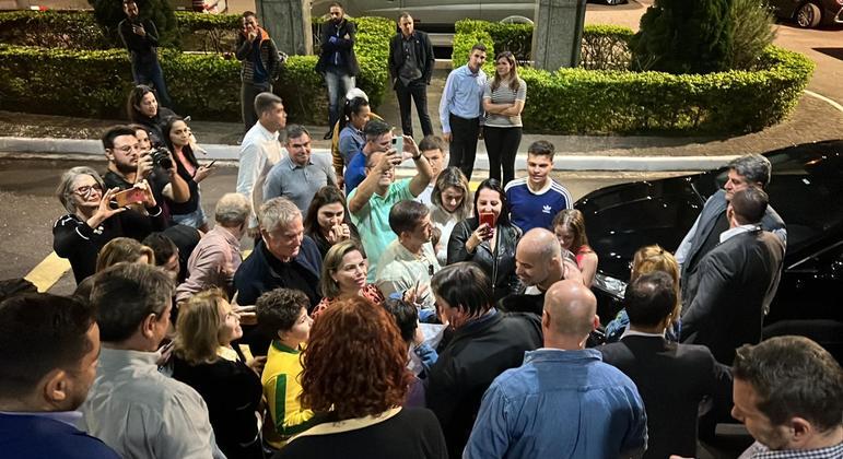 O presidente Jair Bolsonaro é cercado por apoiadores durante caminhada em São Paulo nesta sexta (8)