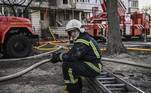 Bombeiro descansa após conter incêndio causado por bombardeio russo em área residencial de Kiev