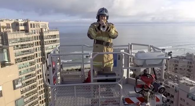 Bombeiro toca trompete do alto da escada mecânica