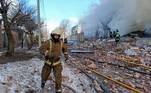 Bombeiros apagam fogo de armazém e observam área destruída após ataque russo em Kharkiv, na Ucrânia