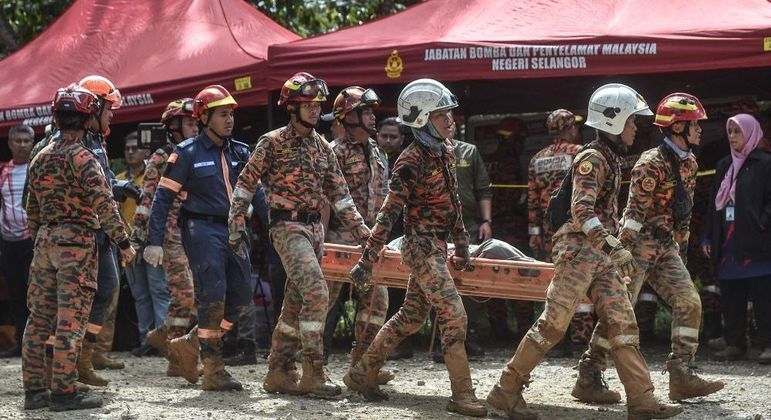 Bombeiros trabalham no resgate das vítimas do deslizamento na cidade de Batang Kali