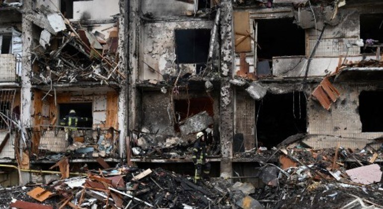 Bombeiros em meio aos destroços de um prédio residencial no subúrbio da capital ucraniana, Kiev