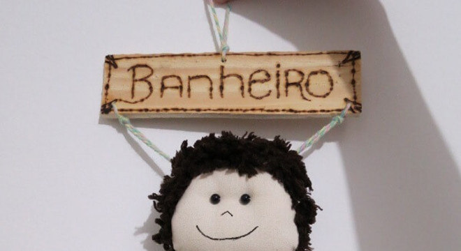 Boneco menino utilizado com enfeite para porta de banheiro