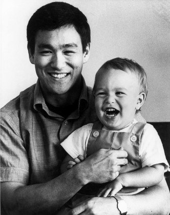 Brandon Lee nasceu em 1/2/1965 na Califórnia. Ele tinha 8 anos quando o pai morreu. Na foto, Bruce com Brandon no colo. 