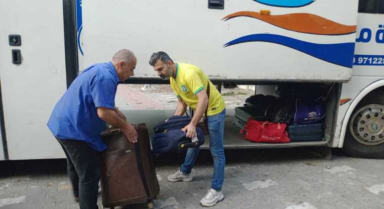 Brasileiros se prepando para embarcar em ônibus que os levará para a fronteira com o Egito