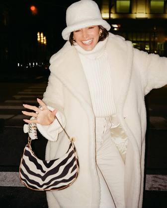 Você prefere usar o bucket hat para compor um visual — quase — monocromático? Bruna também dá exemplo no maior estilo 'dama de branco'. A bolsa com estampa animal também confere contraste e charme ao figurino