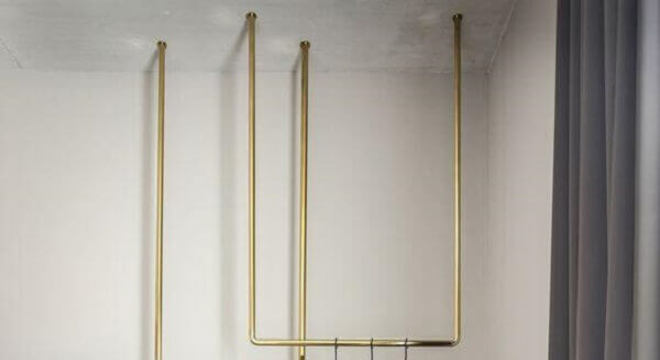 cabideiro arara dourado preso ao teto 