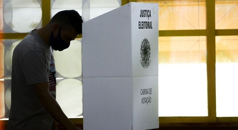 Eleitor na cabine de votação digitando os candidatos de sua preferência durante as eleições
