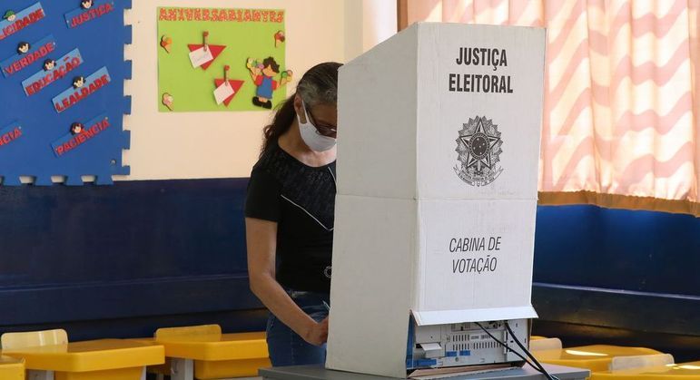 Mulher vota em cabine eleitoral; prazo para solicitar o voto em trânsito segue até 18 de agosto
